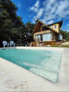 a house with a swimming pool in front of a house at Mirador in San Pedro
