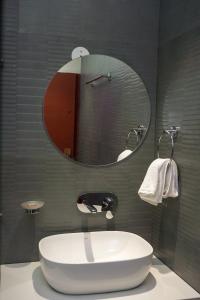 a bathroom with a large white tub and a mirror at The Aero Lounge Hotel 2kms From Airport in Amritsar