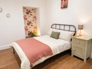 a small bedroom with a bed and a night stand at Steam Mill in Wellow