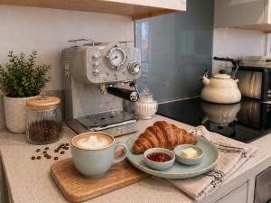 a kitchen counter with a cup of coffee and a plate of bread at Steam Mill in Wellow