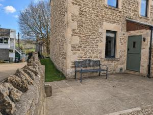 a bench sitting in front of a brick building at Steam Mill in Wellow