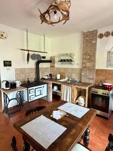 a kitchen with a wooden table and a kitchen with a stove at Halháza vendégház in Sirok