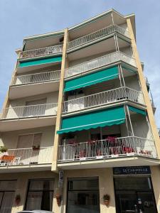 a tall apartment building with balconies and tables at Hotel & Trattoria Le Caravelle in Lavagna