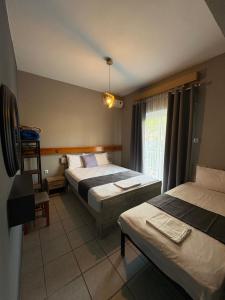 a hotel room with two beds and a window at Amelies Apartments in Paralia Katerinis