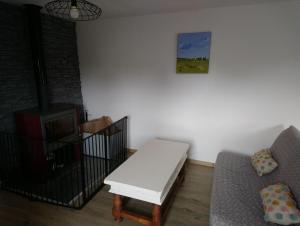 a living room with a couch and a table at Le Logis du Commis in Notre-Dame-dʼElle