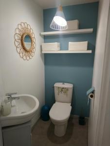 a bathroom with a white toilet and a sink at Le Logis du Commis in Notre-Dame-dʼElle