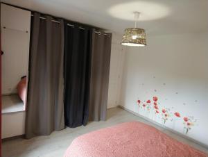 a bedroom with gray curtains and a chandelier at Le Logis du Commis in Notre-Dame-dʼElle