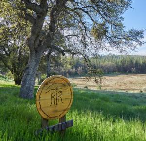 a wooden sign in the grass next to a tree at Red Tail Ranch in Groveland
