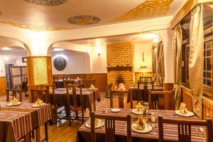 a restaurant with tables and chairs and a fireplace at Netuk House a heritage boutique stay in Gangtok
