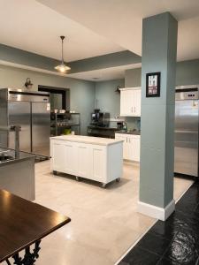 a large kitchen with white cabinets and stainless steel appliances at Blue Water House in Bundoran