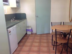 a kitchen with a table and a sink and a table and chairs at Ayr Max Motel in Ayr