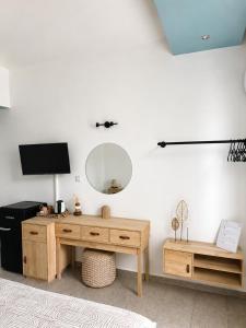 a room with a desk and a mirror on the wall at Delfini Pearl Stegna Beach in Archangelos +25 photos