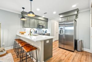 a kitchen with a stainless steel refrigerator and bar stools at Roaring On Ross In Auburn in Auburn