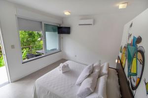 a white bedroom with a bed and a window at Villa dos Graffitis Pousada in Morro de São Paulo +29 photos
