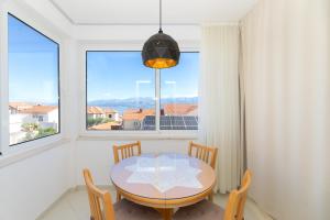 a dining room with a table and chairs and a window at APARTMENTS JELENA 1,2,3,4 & 5 SUPETAR - free parking in Supetar