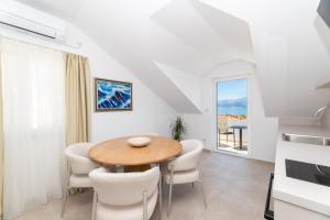 a kitchen and dining room with a table and chairs at APARTMENTS JELENA 1,2,3,4 & 5 SUPETAR - free parking in Supetar