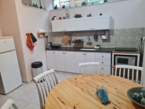a kitchen with a wooden table and a kitchen with a table and chairs at המקום של אמי Emmys Place in ‘En Ha‘Emeq
