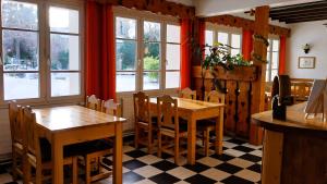 a dining room with two tables and windows at Hôtel Bellier in La Chapelle-en-Vercors +16 photos