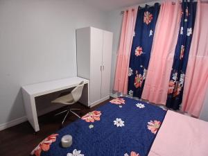 a bedroom with a bed and a desk and curtains at Dreamdoor Apartments in Moncton