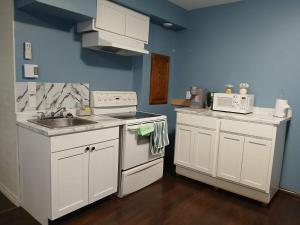 a kitchen with white appliances and a sink at Dreamdoor Apartments in Moncton