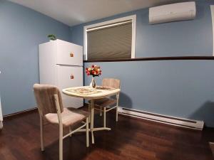 a kitchen with a table and two chairs and a refrigerator at Dreamdoor Apartments in Moncton +2 photos