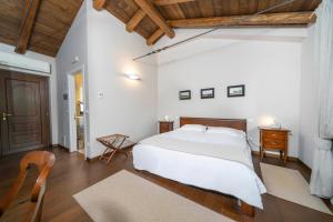 a bedroom with a white bed and a wooden ceiling at Bastianich Rooms in Gagliano