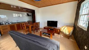 a living room with a couch and a kitchen at Retiro dos Cabritos in São Mateus