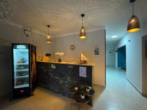 a restaurant with a counter and three pendant lights at Pousada Pedra que Canta in Itamaracá