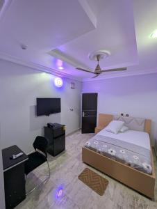a bedroom with a bed and a flat screen tv at WAB STAR Lodge in Kumasi
