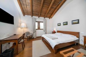a bedroom with a bed and a desk and a computer at Bastianich Rooms in Gagliano