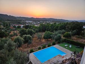 an overhead view of a swimming pool in a yard with a sunset at Quinta do Penedo- Refúgio de Charme e Natureza in Ferreira do Zêzere