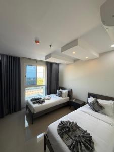 a bedroom with two beds and a window at نايس فيو بانوراما للشقق الفندقية in Al Jubail