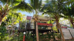 a tree house with a balcony in between two palm trees at Hill Zone Home Stay by Little Paradise in Haad Rin