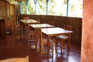 a row of wooden tables and chairs in a restaurant at Hotel La Caravelle in Ambatoloaka