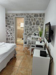 a bedroom with a bed and a table with a television at Anastasija & Tara in Ðuraševići