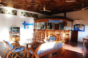 Habitación con sillas, mesa y TV. en Hotel La Caravelle en Ambatoloaka