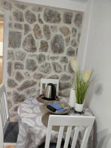 a table with two chairs and a stone wall at Anastasija & Tara in Ðuraševići