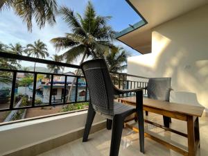 a balcony with a wooden table and two chairs at Darsy Residency and beach cottages in Agonda
