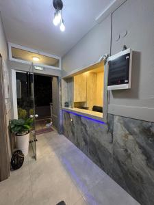a room with a kitchen with a tv on a wall at Amelies Apartments in Paralia Katerinis