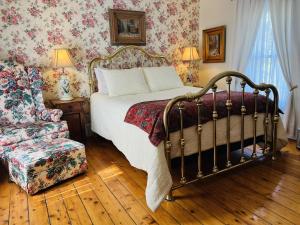 a bedroom with a bed and a chair and flowers at Beacon Hermitage in Beacon