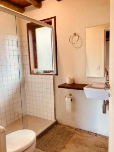 a bathroom with a shower and a toilet and a sink at Flats Bon Voyage Caboré - Chez Cira in Paraty +65 photos