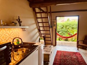 a kitchen with a sink and an open door at Flats Bon Voyage Caboré - Chez Cira in Paraty