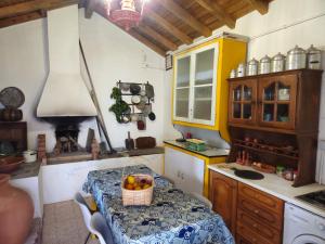 a kitchen with a table with a basket of fruit on it at Quinta do Penedo- Refúgio de Charme e Natureza in Ferreira do Zêzere