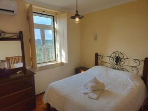 a bedroom with a bed and a dresser and a window at Quinta do Penedo- Refúgio de Charme e Natureza in Ferreira do Zêzere +99 photos