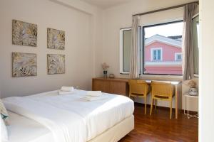 a white bedroom with a bed and a table and chairs at Pinia Penthouse by Corfuescapes in Corfu
