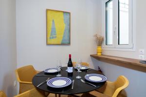 a black table with chairs and a bottle of wine at Pinia Penthouse by Corfuescapes in Corfu