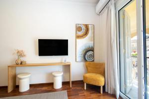 a living room with a tv and a chair at Pinia Penthouse by Corfuescapes in Corfu