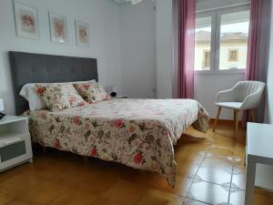 a bedroom with a bed and a chair and a window at Puerta del Sol - Plasencia in Plasencia