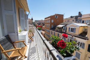 a balcony with chairs and flowers on a building at Pinia Penthouse by Corfuescapes in Corfu