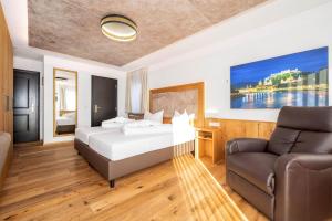 a hotel room with a bed and a couch at Hotel Rupertihof in Ainring